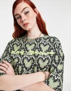 Love Moschino – Kastiges T-Shirt mit All-over-Herzprint in Grün